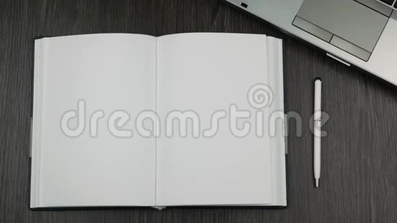 办公室桌子上空白开放日记的顶部视图商人手翻页视频的预览图