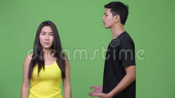 年轻的亚洲女人向年轻的愤怒的亚洲男人示警视频的预览图