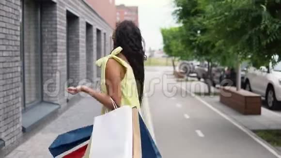年轻的女孩穿着一件长裙手里拿着袋子购物4K视频的预览图