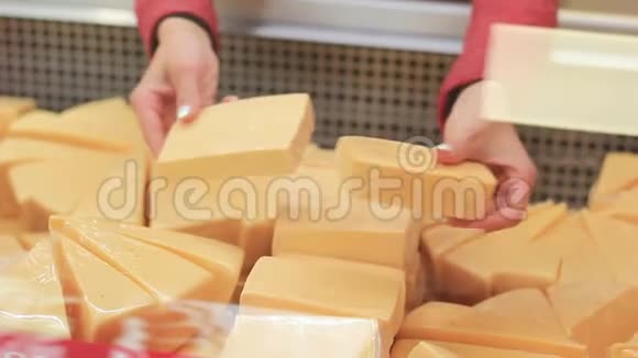 女人的手在整理商店冷藏设备中的奶酪视频的预览图