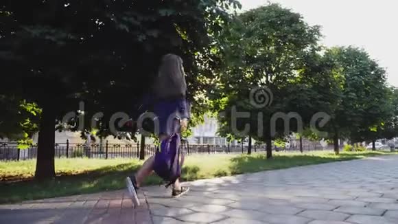 女孩挥舞着背包跑过小巷视频的预览图