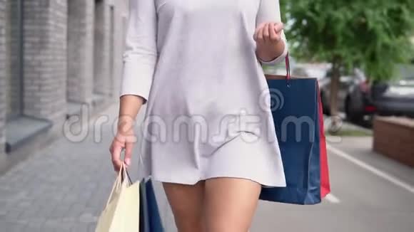 女孩穿着一件浅色连衣裙留着长发购物后手里拿着东西慢动作高清高清视频的预览图