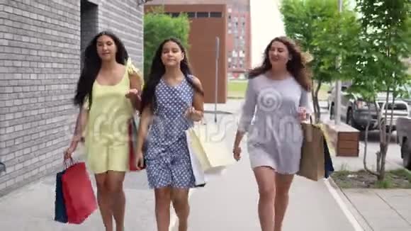 三个漂亮的女孩购物后走在街上4K视频的预览图