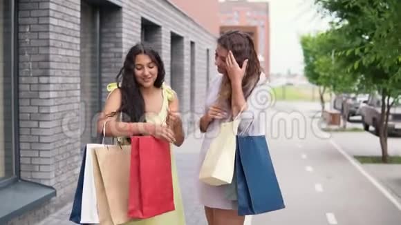 两个穿连衣裙的女朋友在购物后讨论购物慢动作视频的预览图