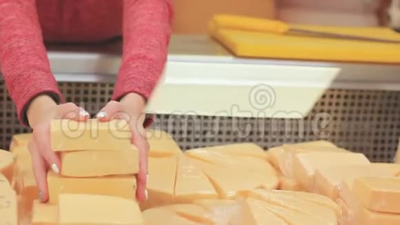 女人的手在整理商店冷藏设备中的奶酪视频的预览图