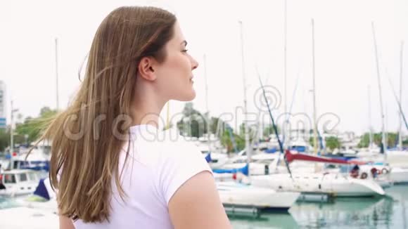 年轻女子独自站在码头上灵感来自无忧无虑的女性她缓慢地举起手臂视频的预览图