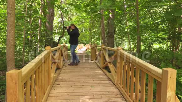 男子在公园的木桥拍照视频的预览图