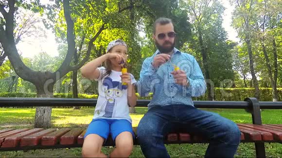 一个留胡子的人和他的女儿一起吹肥皂泡TT视频的预览图
