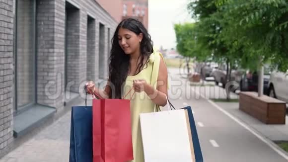 快乐的年轻女孩在购物后用包裹看她的购物慢动作视频的预览图