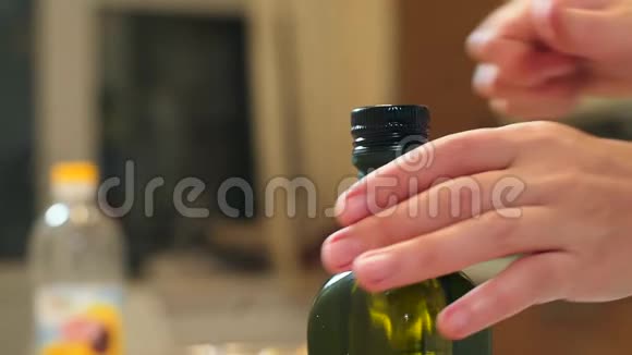 女性手打开瓶子里的油加入土豆橄榄油视频的预览图