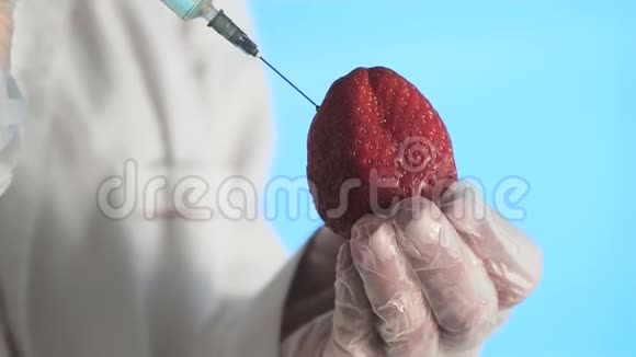 男性科学家用注射器将物质注入草莓视频的预览图