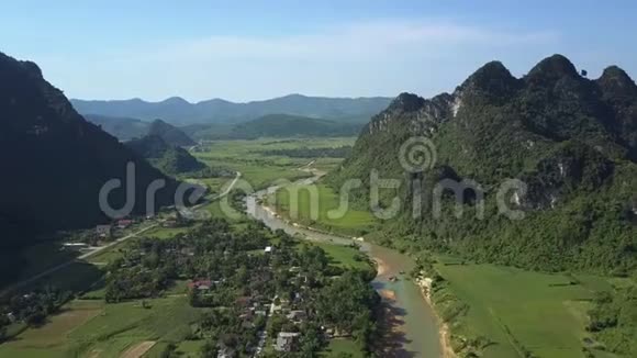 Flycam沿着河流的道路在群山之间的山谷中奔跑视频的预览图
