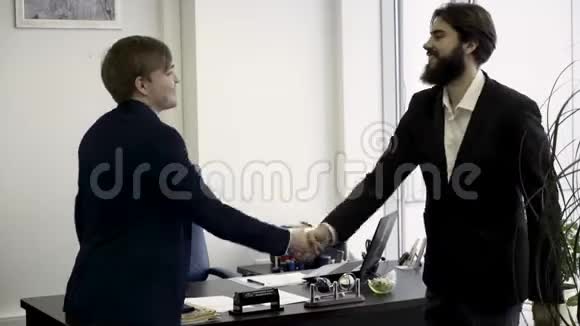 快乐微笑的商人站在现代化的办公室里握手很高兴见到你的手势升职了视频的预览图