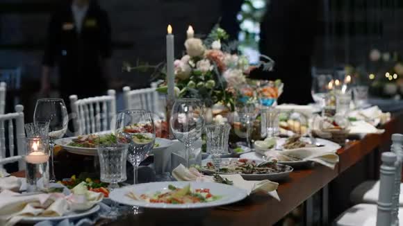 餐厅的婚桌宴会厅装饰有蜡烛和鲜花视频的预览图