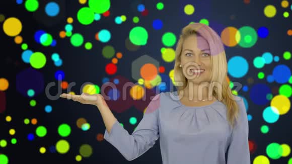 年轻女子微笑着站着握着她的手在张开的手掌上展示一些东西广告产品的概念视频的预览图