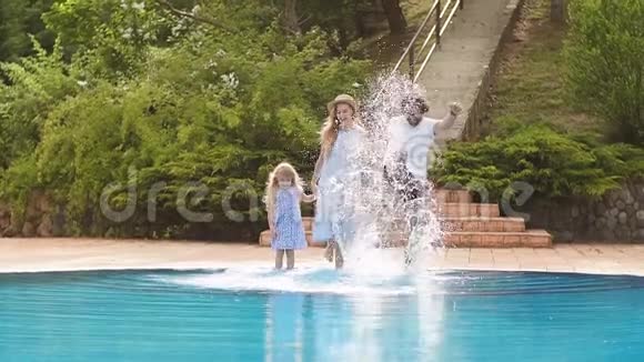 暑假的家庭假期有孩子的父母在游泳池附近玩视频的预览图