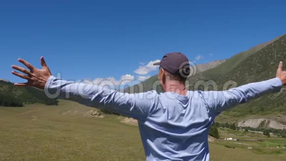 站在山上的人在青山和高原上伸出双臂视频的预览图