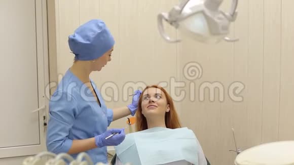 牙医正在治疗坐在牙科椅上的女性病人视频的预览图