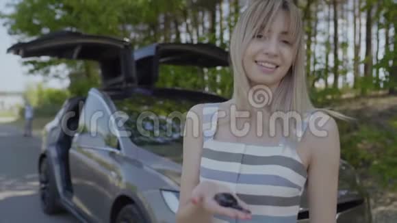 带着车钥匙的年轻微笑女孩视频的预览图
