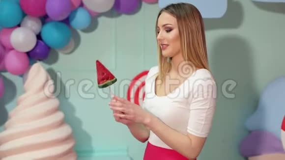 一个快乐女孩的肖像在一个多色球的背景上有一个大糖果视频的预览图
