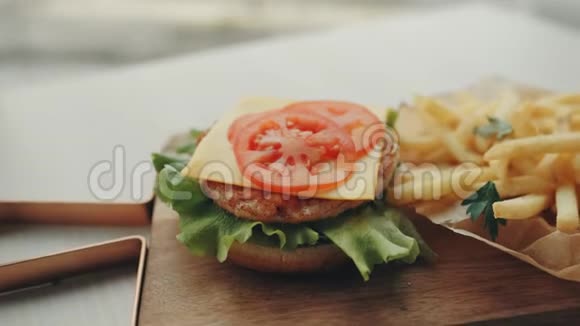 桌上放着汉堡或鸡肉汉堡和炸薯条和番茄酱快餐视频的预览图