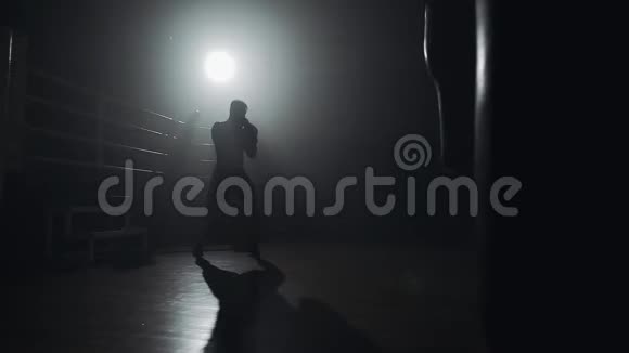 剪影拳击手在黑暗的健身房打拳体力锻炼男拳击手在黑暗中锻炼跆拳道剪影视频的预览图