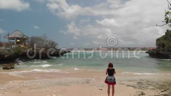 4K飞行无人机视频年轻女子在热带野生岩石海滩拍照巴厘岛视频的预览图
