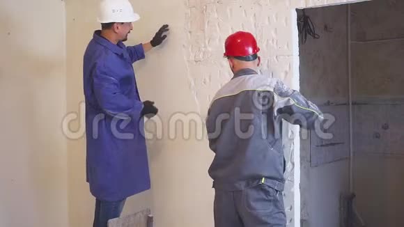 两名工人穿着防护服拆除石膏墙视频的预览图