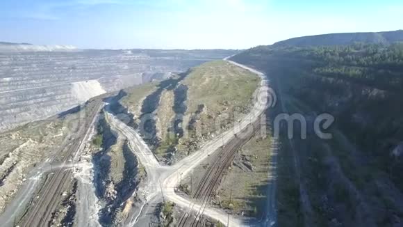 卡车绕石棉坑蜿蜒的空中地面道路视频的预览图