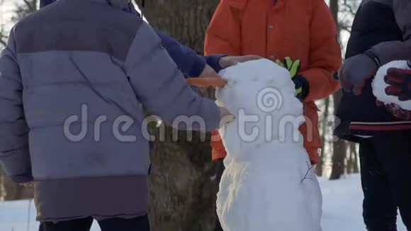 5个男孩在冬季公园堆雪人视频的预览图