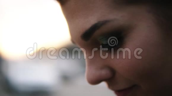 非常接近女性脸的镜头仔细地看着明亮模糊的透视布鲁内特烟雾视频的预览图
