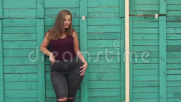 一个在绿色墙旁边体重超标的女孩视频的预览图