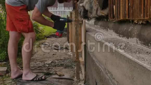 工人拆除木模板为旧房子新建基础4K视频的预览图