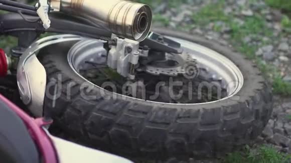 事故撞车或坠落后摩托车车轮在地面上的特写镜头慢动作视频的预览图
