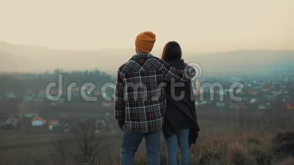 一对年轻的夫妇爱上了憧憬天涯和高山的旅行者背面视频的预览图