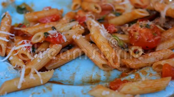 用蓝色盘子的叉子吃带有美味番茄酱肉帕尔马和西红柿的意大利面视频的预览图