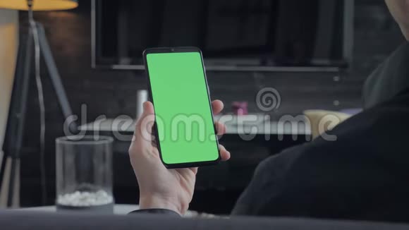 绿色屏幕持有智能手机的人从肩膀上看视频的预览图