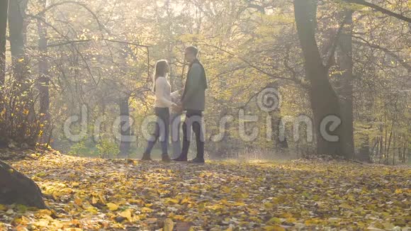 年轻夫妇在秋天的森林里温柔地拥抱浪漫的姿态相爱的人视频的预览图