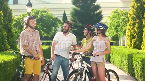 四个骑自行车的人在户外笑慢动作视频的预览图