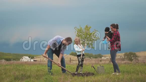 友好的家庭孩子在花园里和父母一起植树视频的预览图
