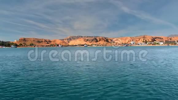 热带景观蓝色绿松石海映衬着沙漠山脉的黄色海岸棕榈树海滩和旅馆视频的预览图