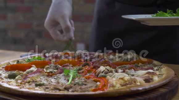 食品装饰理念厨师在意大利披萨店用新鲜的草药装饰烤披萨过程准备视频的预览图
