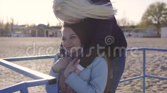 家庭休闲轮椅上的年轻残疾妇女和她的母亲一起在斜坡上的海边散步视频的预览图