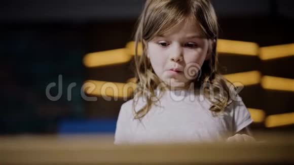 可爱冷静的小女孩在室内读一本大书视频的预览图