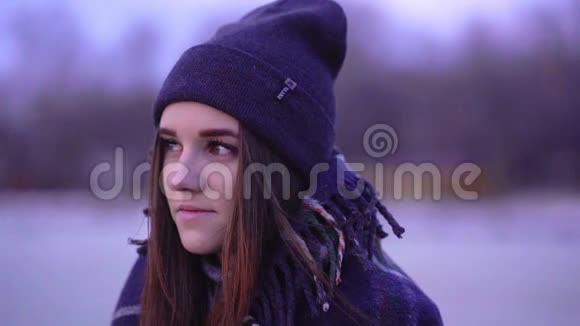 一个年轻漂亮的冻僵的女孩戴着运动帽和一个温暖的格子的肖像视频的预览图