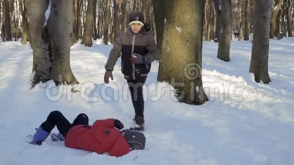 男孩帮助弟弟从雪中站起来视频的预览图