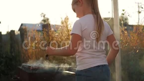 小女孩在绿色草坪的烤架上做烧烤视频的预览图