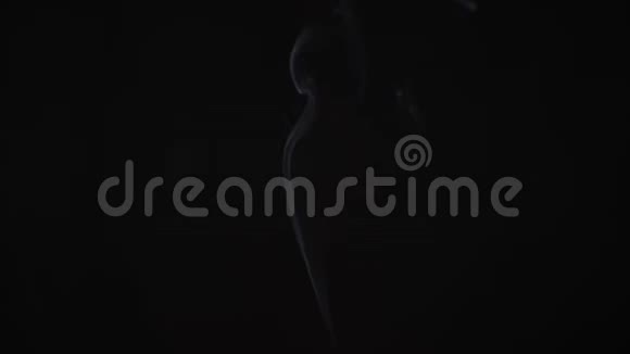 一条薄薄的烟雾从屏幕上升起在黑色背景上背光拍摄视频的预览图