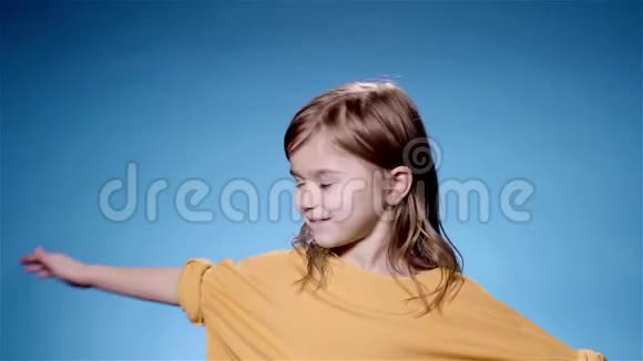 微笑的黄色旋转的小女孩蓝色背景超级慢动作视频的预览图