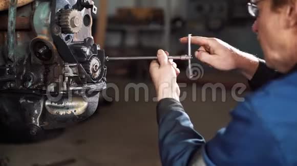 一个工人在维修中心修理一辆坏汽车的发动机视频的预览图